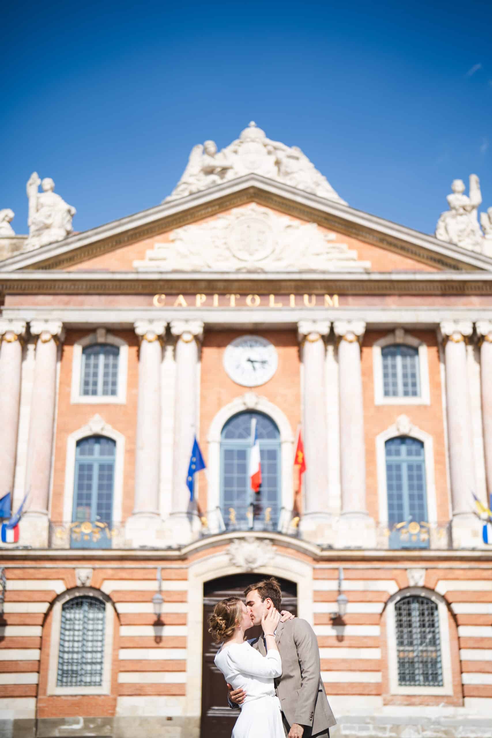 Newlyweds kiss in front of the capitol building in Toulouse - Toulouse Wedding photographer 