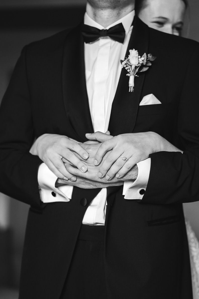 The bride embracing the groom from behind during the first look at Halte en Cocagne