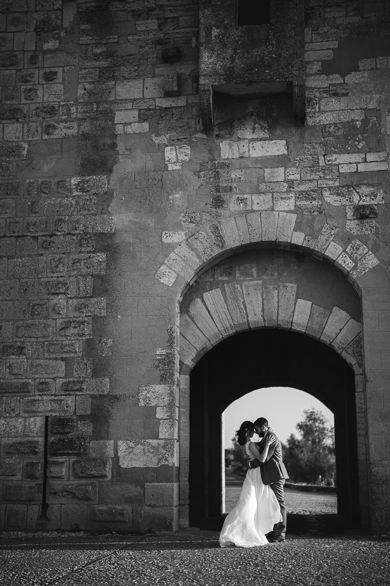 Married couple under the arch of Tour Carbonnière in Camargue during a day after session