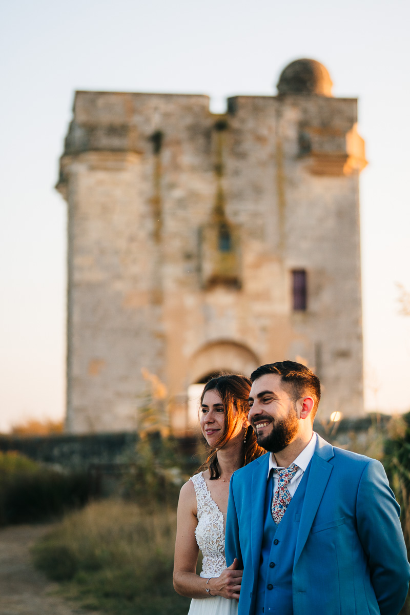 Married couple in front of Tour Carbonnière during golden hour