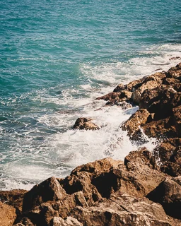 Close-up of rocks and the Mediterranean Sea in the port of Antibes on the French Riviera