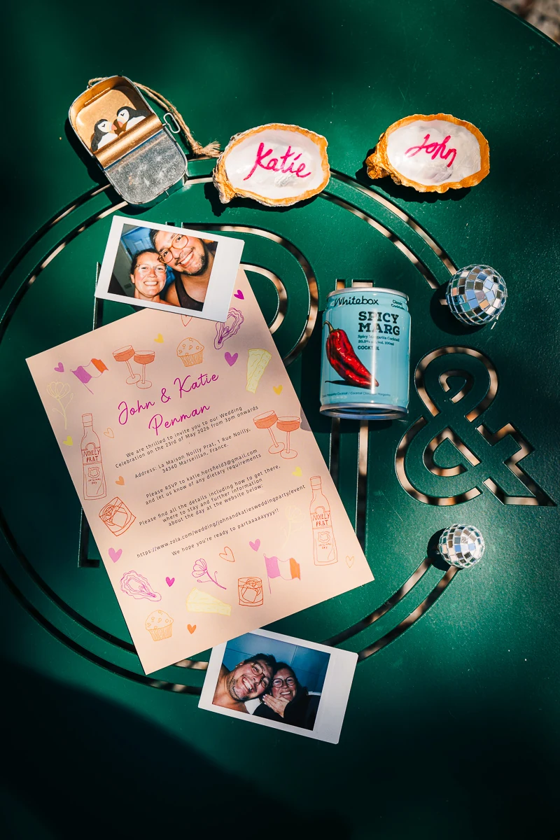Wedding invitation with photo booth polaroids pinned on a green background