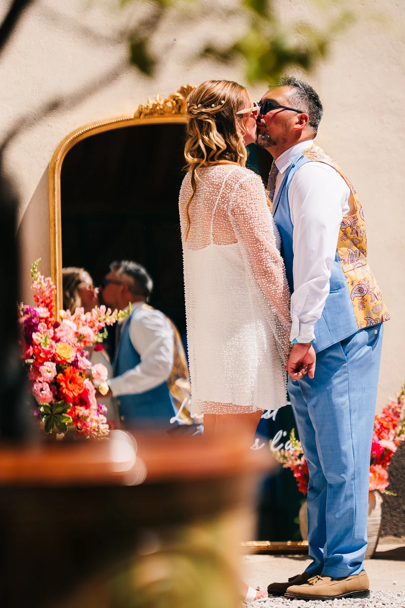 Bride and groom kissing in front of a mirror