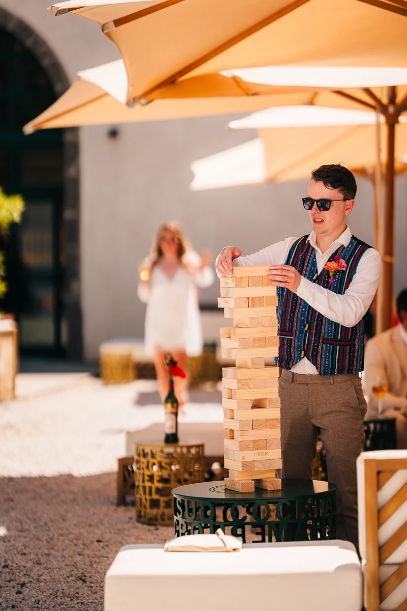 wedding guest trying a jenga tower - shaded terrace