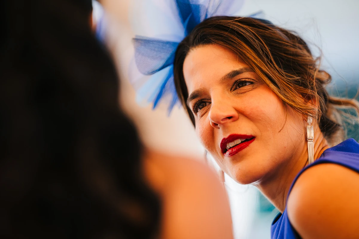 Close-up portrait of a wedding guest in a blue dress with red lipstick