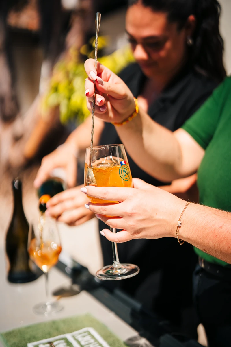 A close-up of the bartender's hands as she prepares a cocktail for the guests
