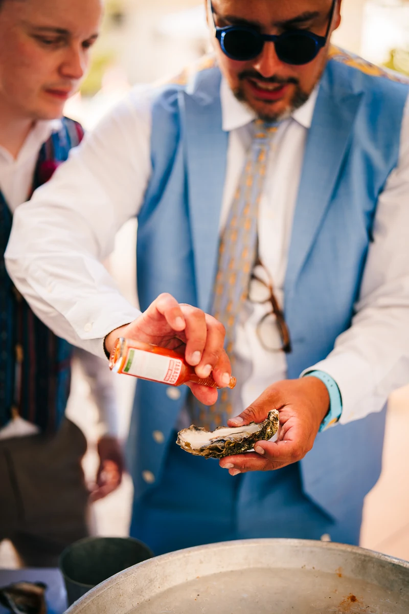 Groom in a light blue suit preparing oyster