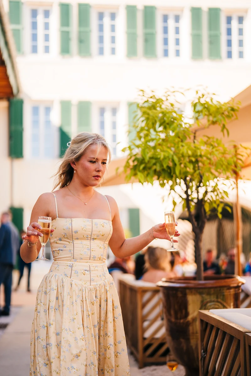 A guest with a glass in her hand, outdoors