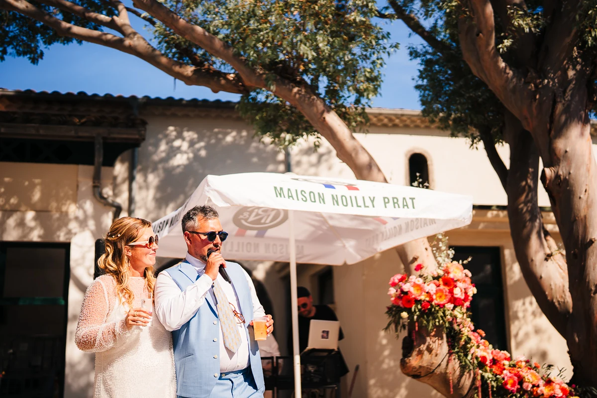Couple toasting with champagne outside the Maison Noilly Prat venue