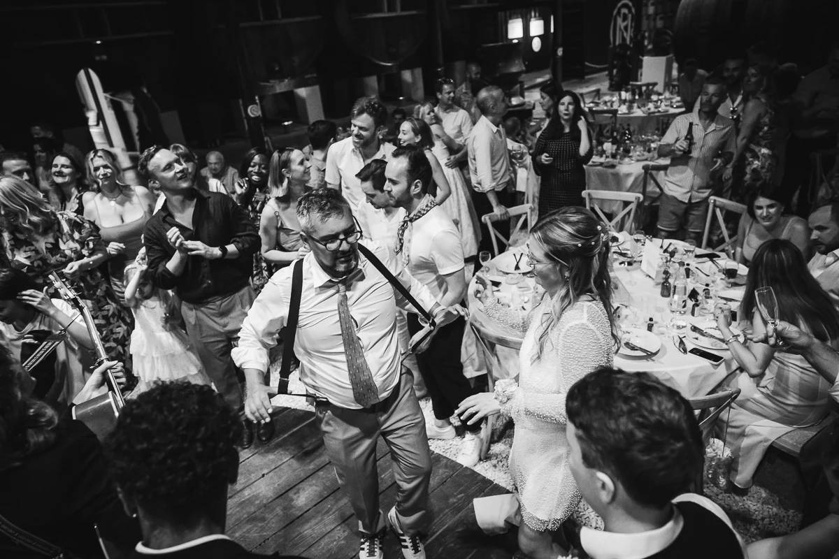 Black and white photo of guests dancing together at the party