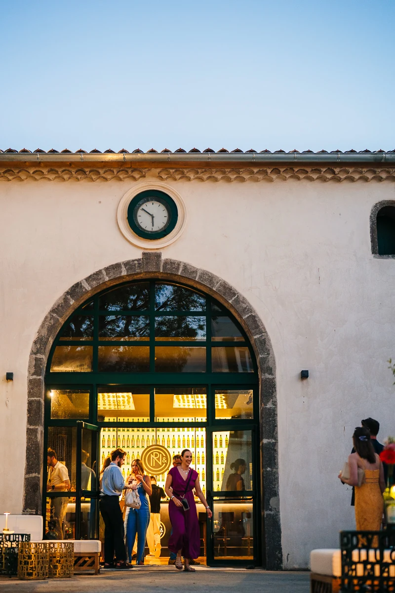 Guests arriving at the illuminated venue entrance in the evening