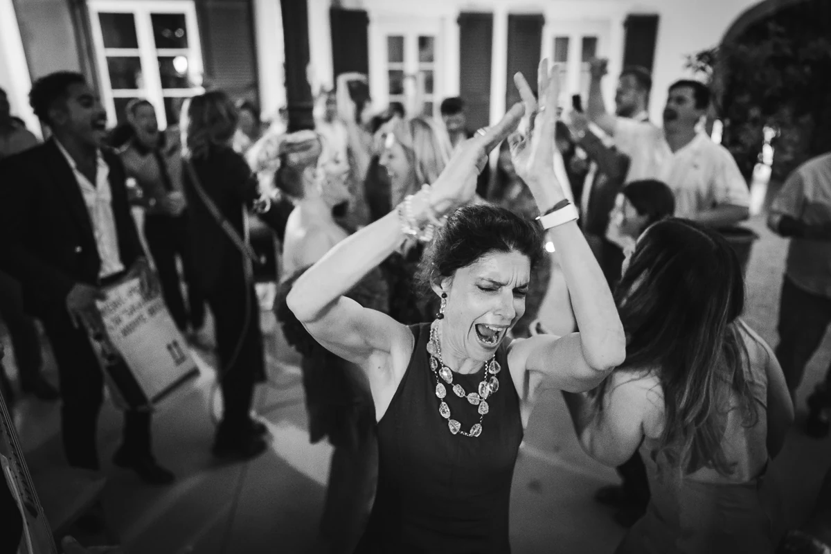 Black and white photo of guests dancing energetically at the party
