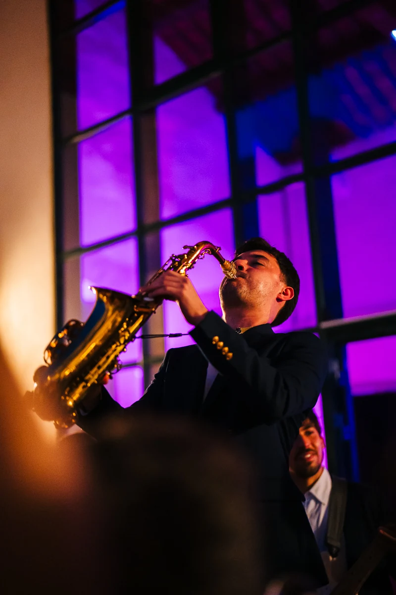 Musician playing the saxophone under colorful stage lights