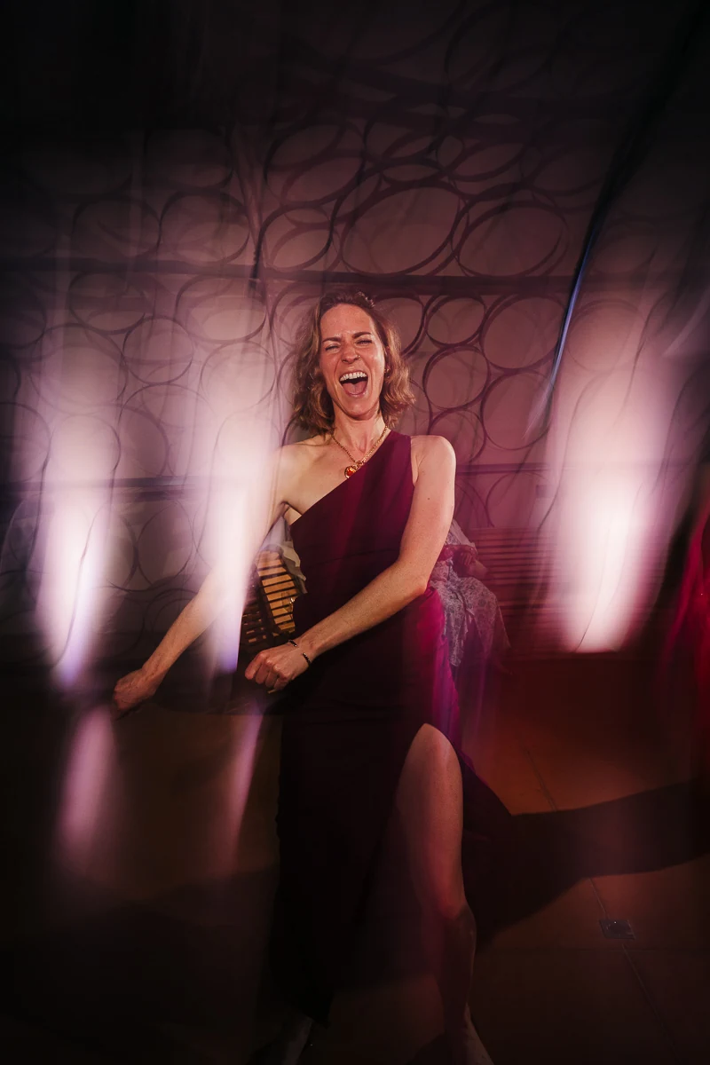 Woman singing and dancing under colorful lights