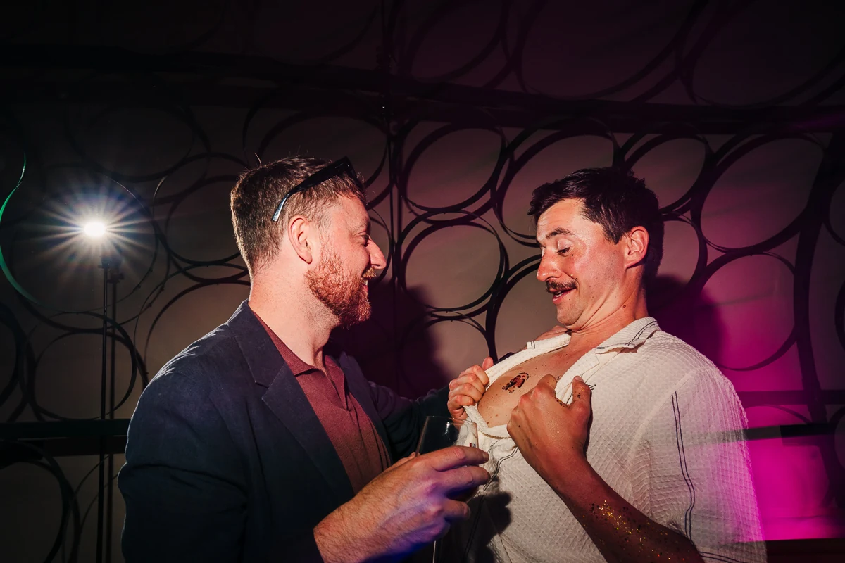 Two men laughing together at the party