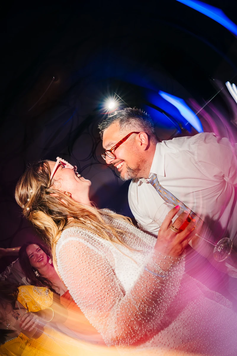 Couple dancing together under blue party lights