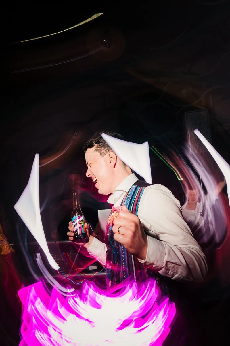 Blurred motion photo of a guest dancing under pink lights