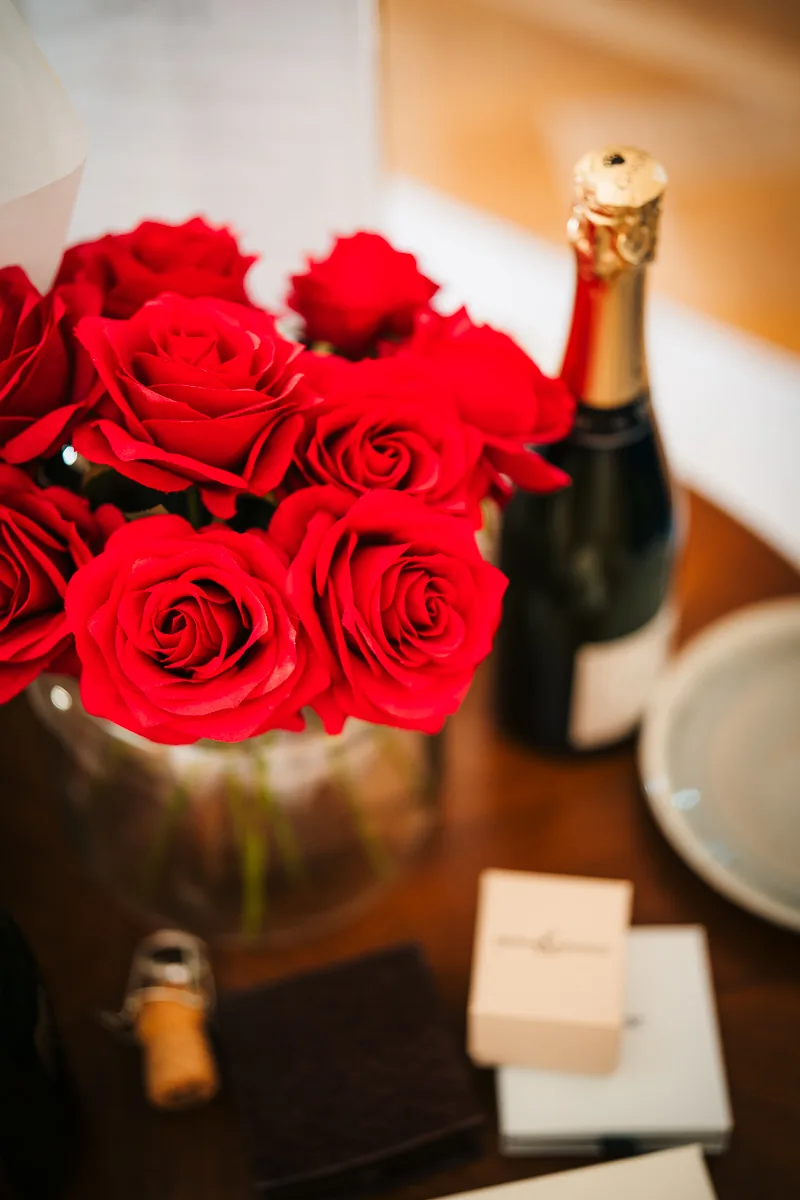 Red roses and a bottle of champagne on a table in the bridal suite, wedding morning in the South of France