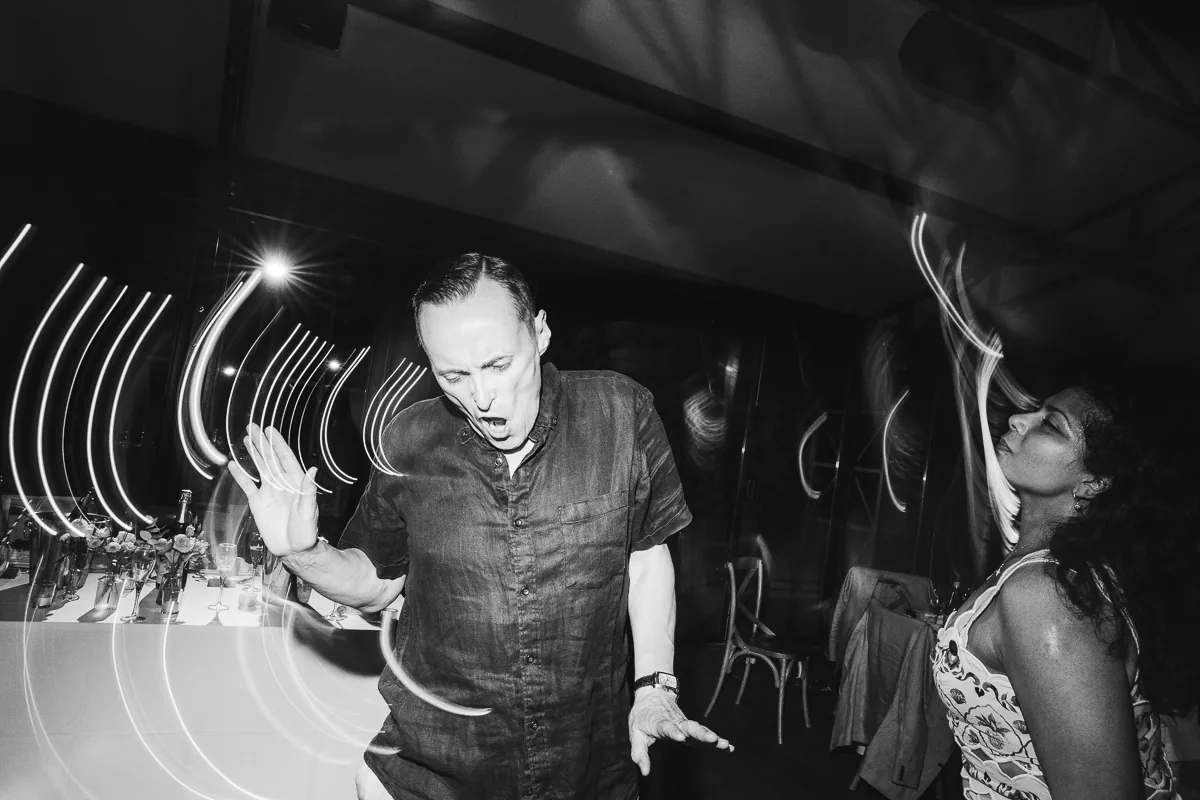 Black and white photo of a guest dancing with light trails on the dance floor at a wedding in the South of France