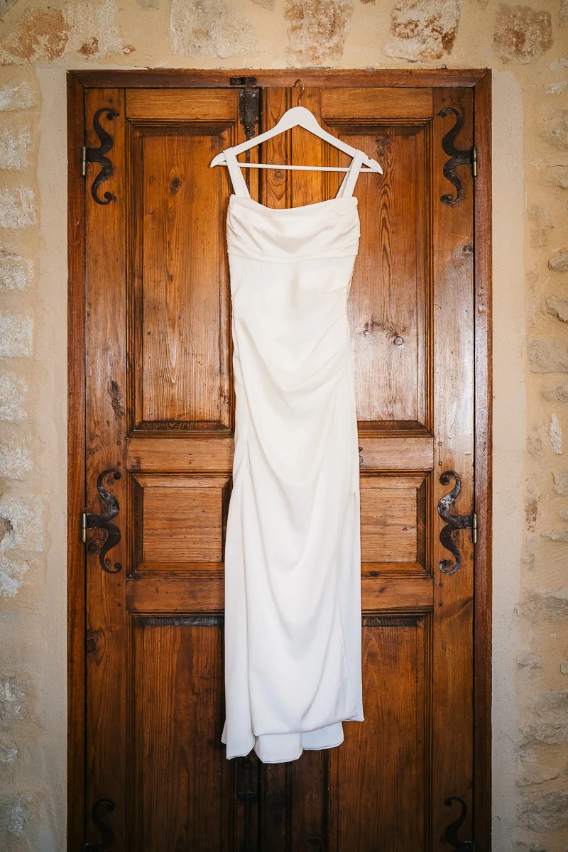 Wedding dress hanging on an old wooden door at Domaine de la Trinité near Montpellier