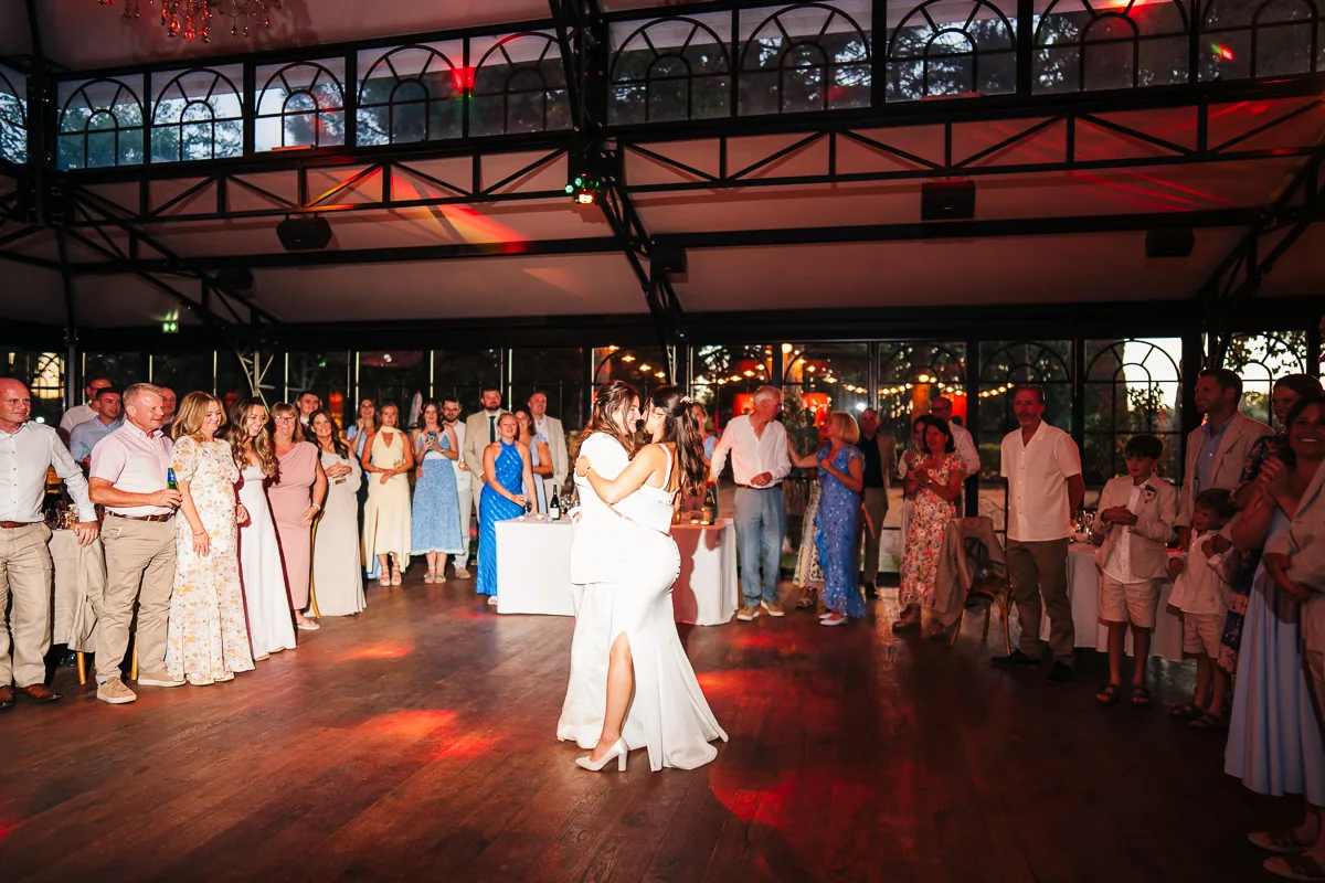 One of the brides dancing while guests watch in the orangery at Domaine de la Trinité