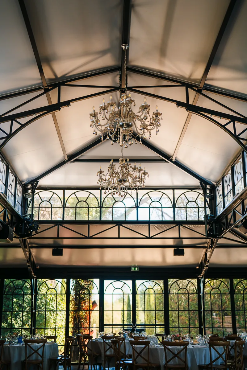 Orangery with double roof, chandeliers and chandeliers and set tables at Domaine de la Trinité, near Montpellier