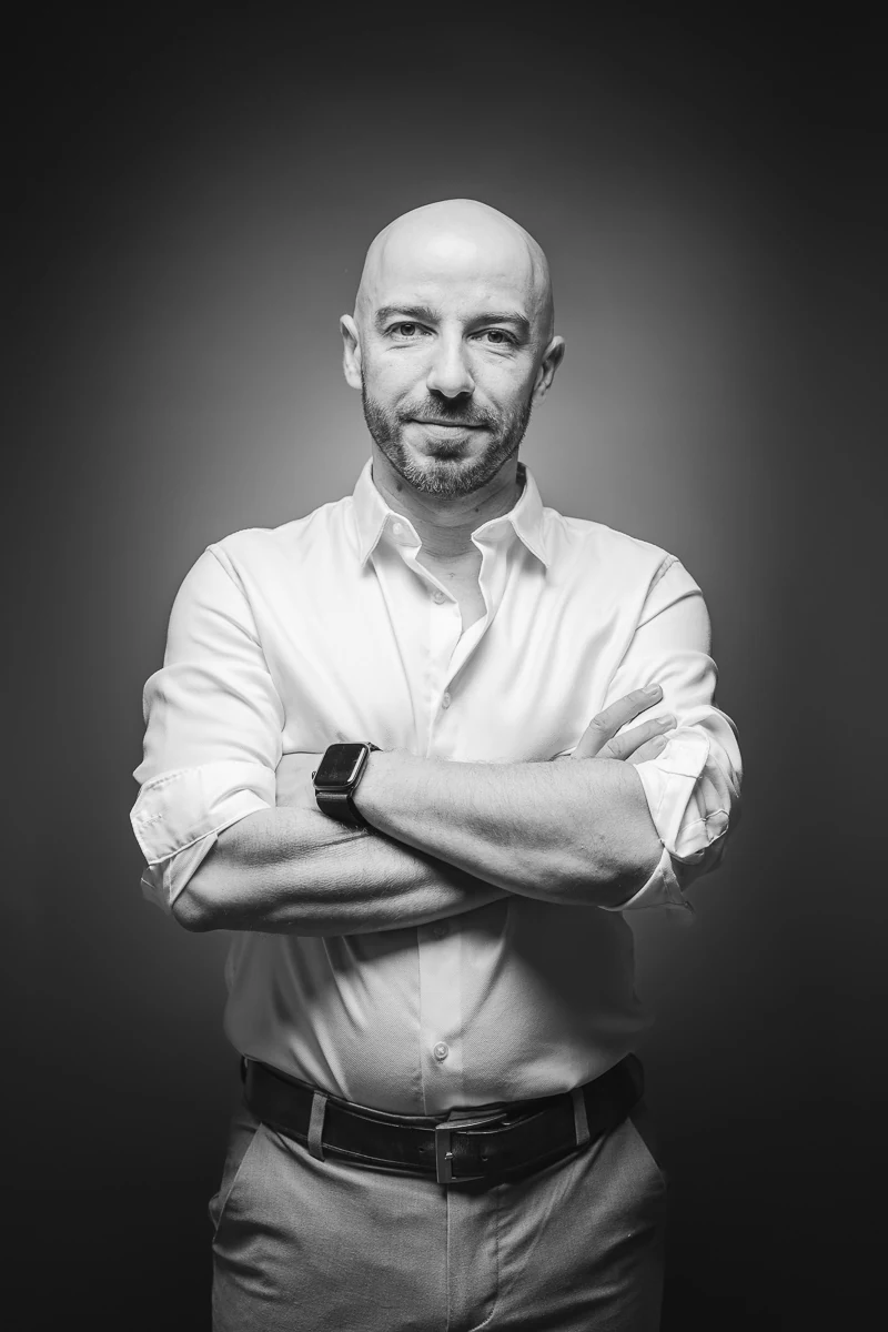 Thibault Maestracci, wedding photographer, black and white portrait in a white shirt, arms crossed
