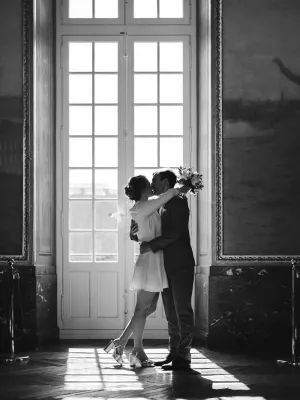 Black and white portrait of a couple by a large window at the Capitole in Toulouse city hall