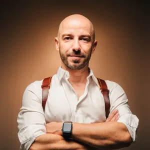 Thibault Maestracci, wedding photographer, smiling with arms crossed, leather camera harness