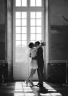 Black and white portrait of a couple by a large window at the Capitole in Toulouse city hall