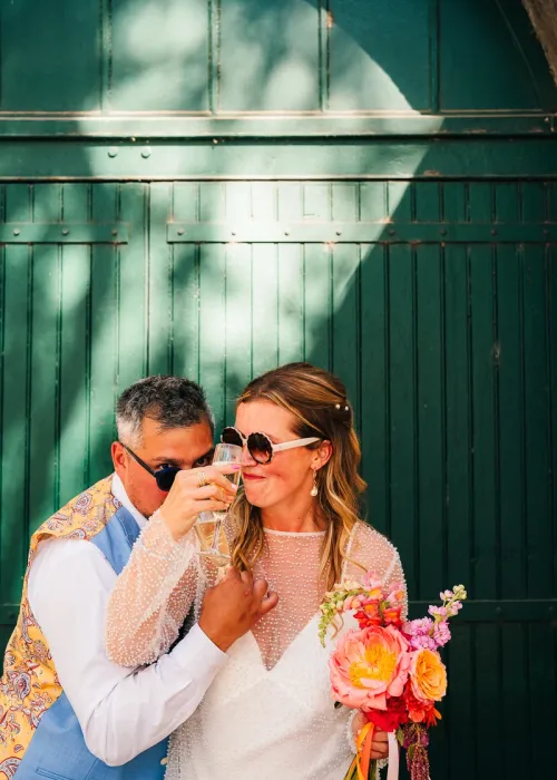 Candid editorial photo of a UK couple toasting with champagne at their wedding party in the south of France